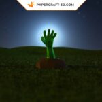 Papercraft of a hand emerging from the ground in 3D origami