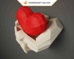 Papercraft hands holding a heart in origami