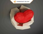 Papercraft hands holding a heart in origami