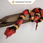 Papercraft of scarlet royal snake on branch