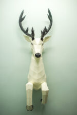 Papercraft deer emerging from wall in 3D origami