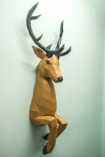 Papercraft deer emerging from wall in 3D origami