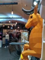 Papercraft deer emerging from wall in 3D origami