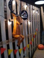 Papercraft deer emerging from wall in 3D origami