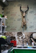 Papercraft deer emerging from wall in 3D origami