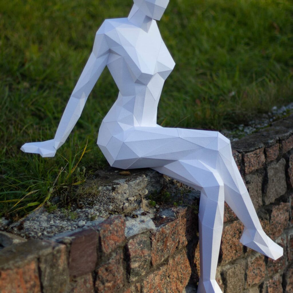 Papercraft of a seated woman in 3D origami