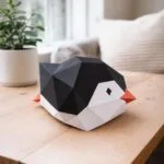 Papercraft babypinguïn glijdend in 3D-origami, weergave 2