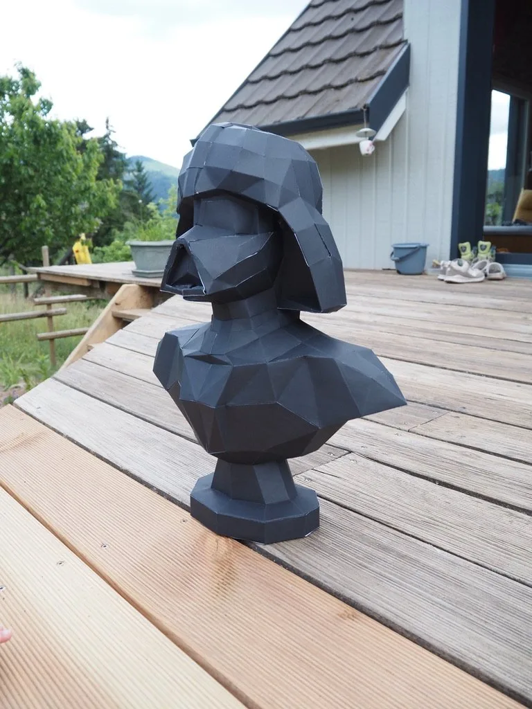 Masque de Dark Vador noir sur terrasse en lames de bois