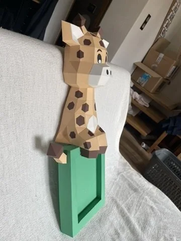 Girafe cartoon assise sur cadre photo vert en papier