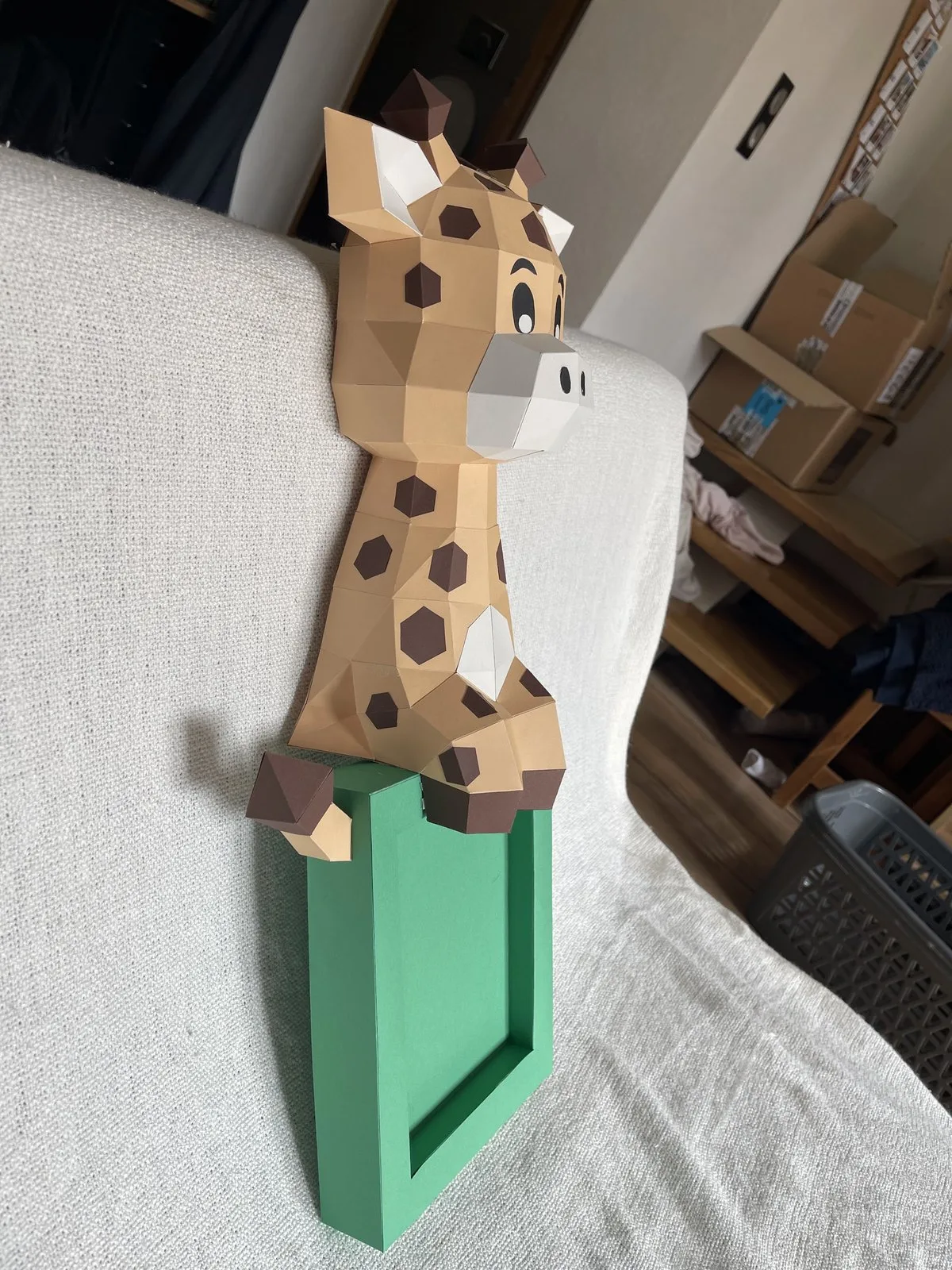 Girafe beige à taches perchée sur cadre photo vert