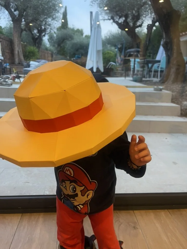 Enfant de dos coiffé du chapeau de Luffy en papier