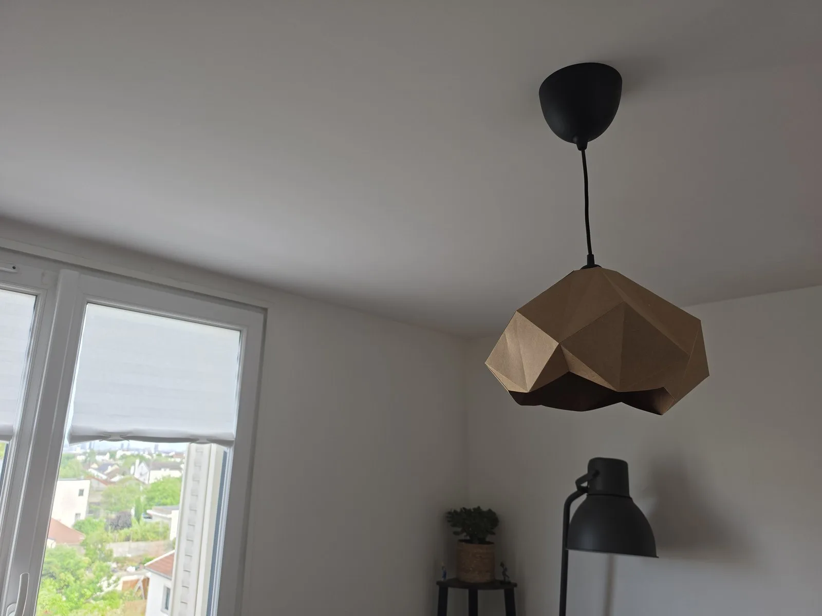 Lampe solstice suspendue éteinte près d’une fenêtre