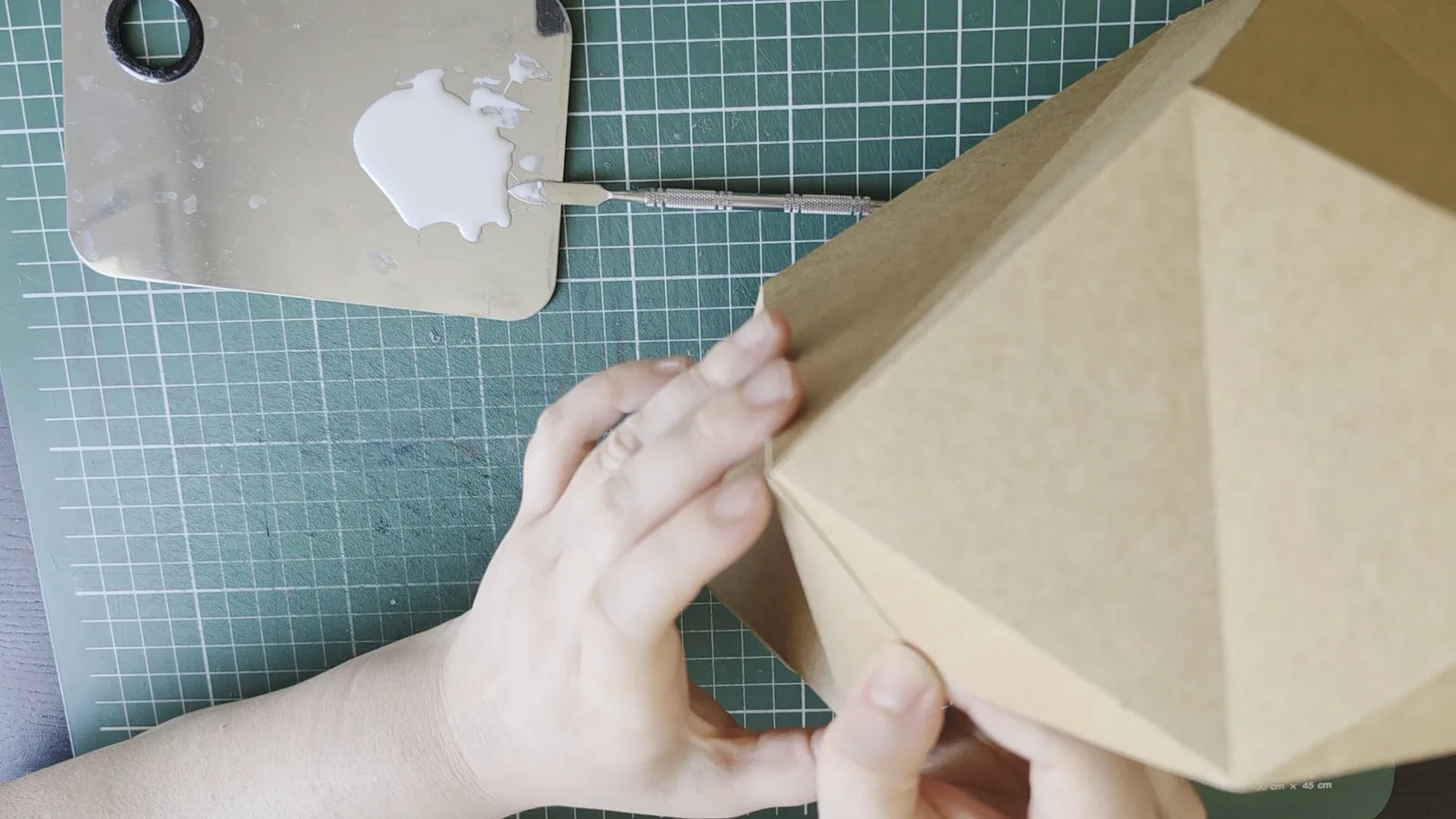 Collage des arêtes d’une lampe en papier kraft
