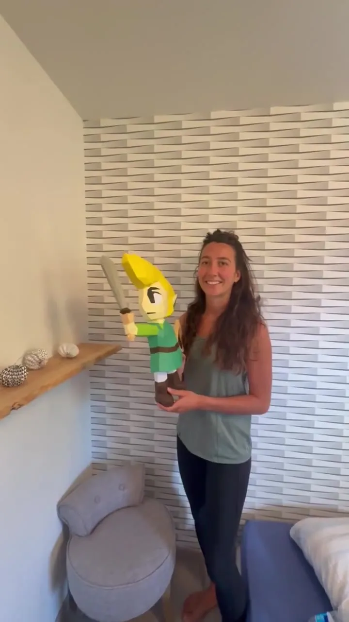 Artisane souriante présentant sa création de Link terminée