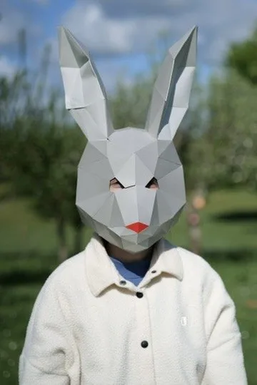 Enfant arborant un masque de lapin blanc à nez rouge