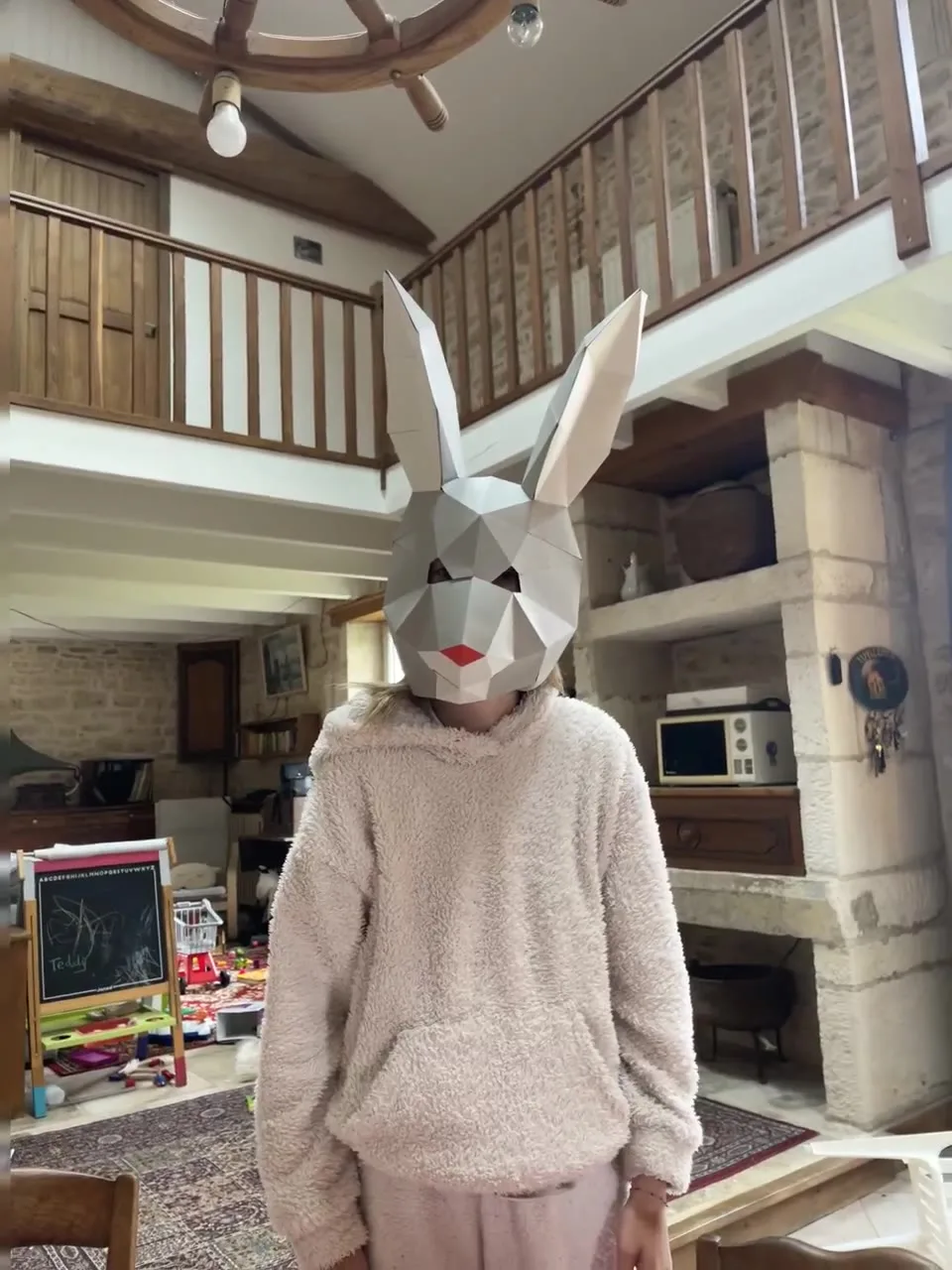 Enfant souriant avec masque lapin gris et nez rouge