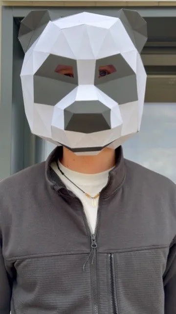 Masque de panda low-poly blanc et gris porté en extérieur