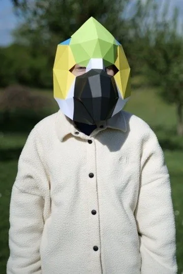 Enfant portant un masque de perroquet vert jaune et blanc