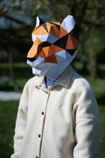 Enfant souriant avec masque de tigre orange dans un parc