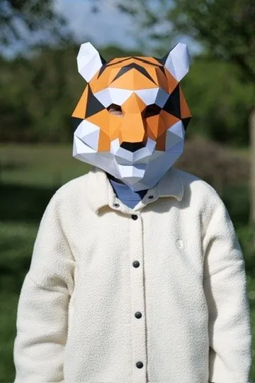 Visage d’enfant avec masque de tigre orange et blanc