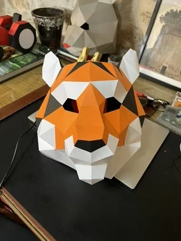 Masque de tigre en papier posé sur bureau en bois
