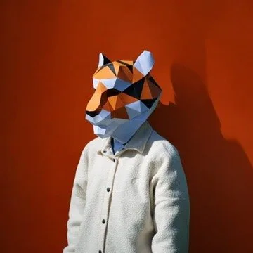 Personne avec masque de tigre orange sur fond rouge vif