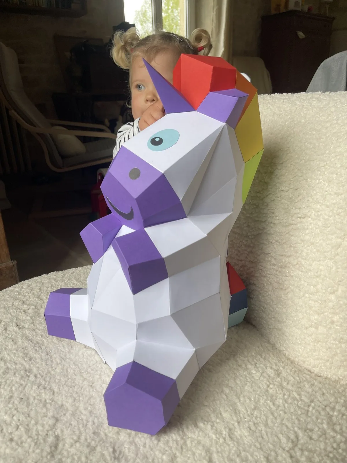 Licorne blanche et violette assise à crinière arc-en-ciel
