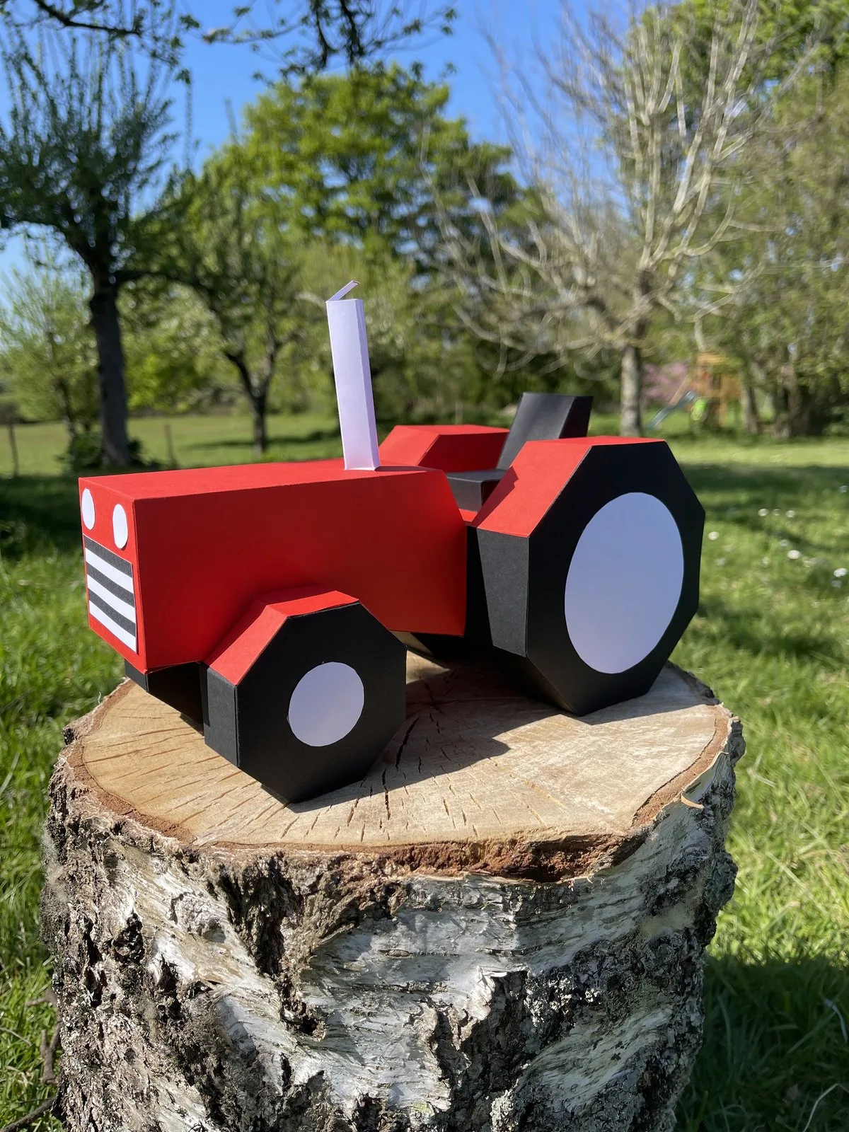 Tracteur enfant rouge à roues noires sur bois