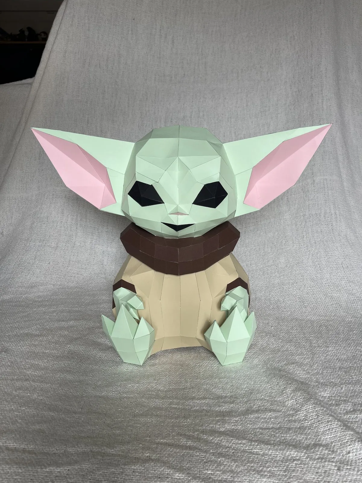 Grogu assis en papier vert pâle avec col marron et oreilles