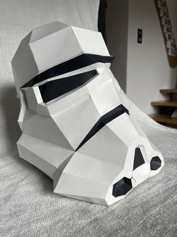 Casque Stormtrooper blanc et noir sur canapé gris