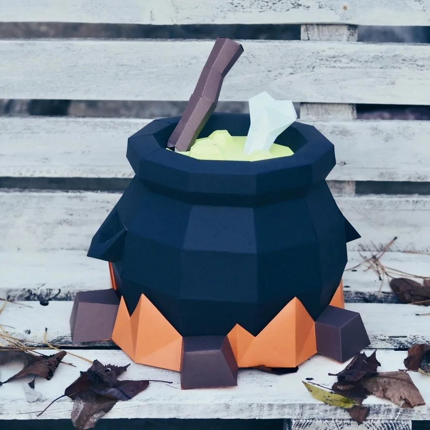 Chaudron de sorcière noir sur braises orange, potion verte, os et cuillère