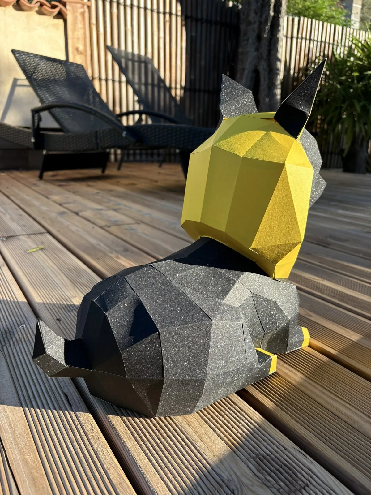 Dos d’un chien en papier noir aux reflets dorés