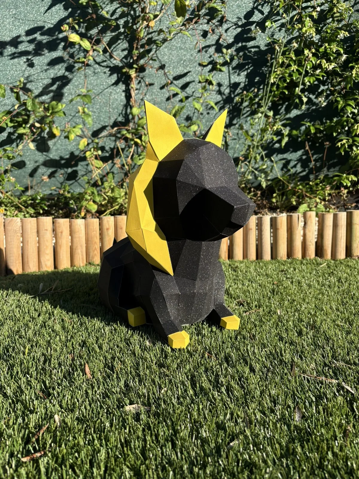 Chien égyptien en papier assis sur pelouse synthétique