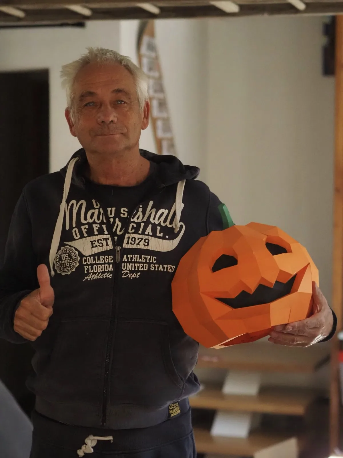 Homme souriant avec citrouille en papier sculptée