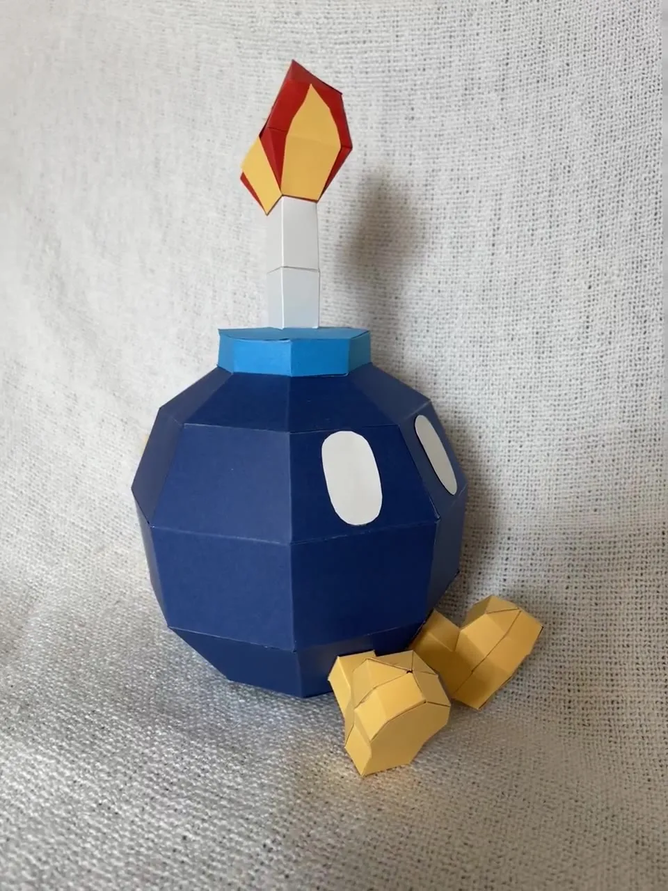 Bob-omb bleu sur tissu blanc avec flamme et pieds jaunes