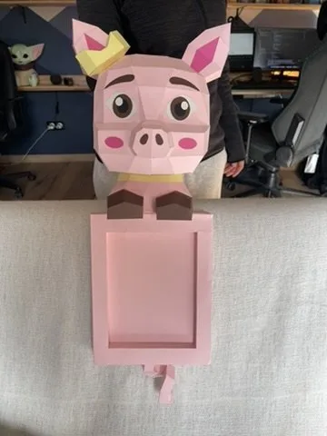 Cochon rose avec couronne jaune dominant un cadre rose