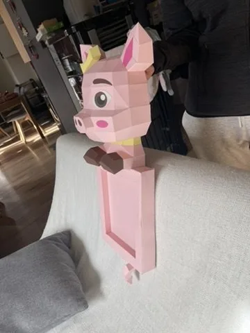 Cochon rose couronné aux pattes brunes sur canapé
