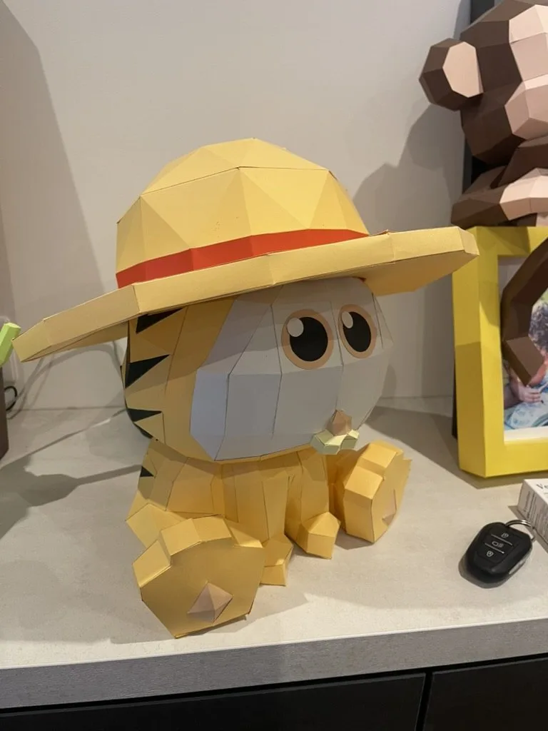 Chaton orange avec chapeau de paille et fond décoré