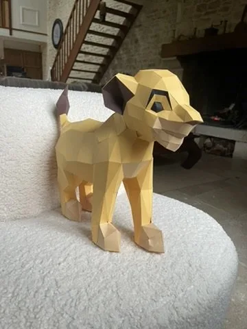 Simba en origami de trois-quarts sur un canapé