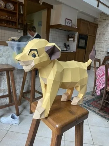 Lionceau Simba en papier de profil sur un tabouret