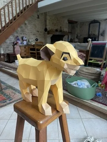 Lionceau Simba assis de profil sur un tabouret