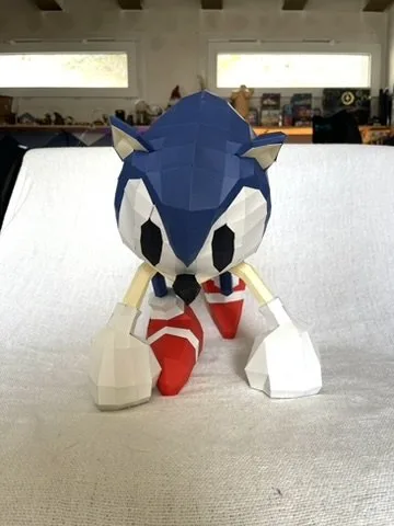 Sonic bleu et blanc assis sur canapé en maquette papier