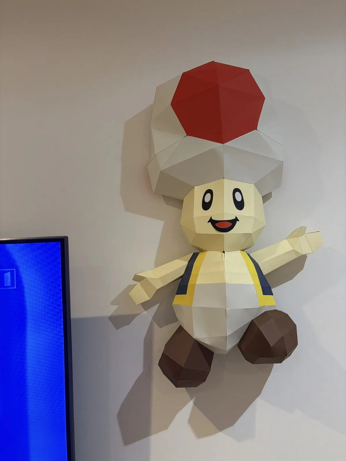 Grande figurine Toad en papier près d une télévision
