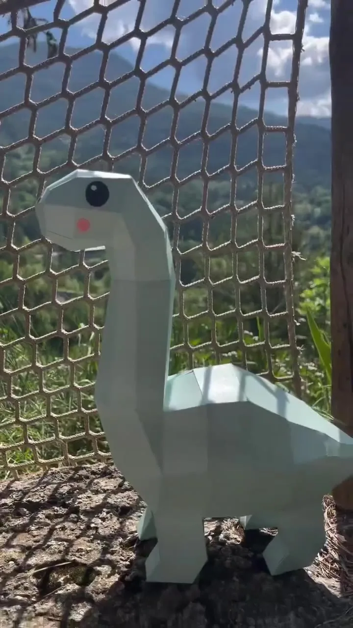 Dinosaure vert au long cou et joues roses en extérieur