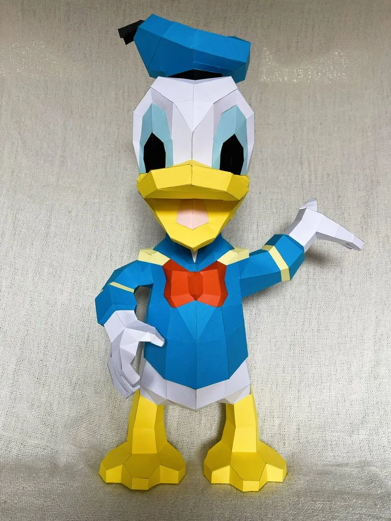 Donald Duck en origami main sur la hanche nœud rouge