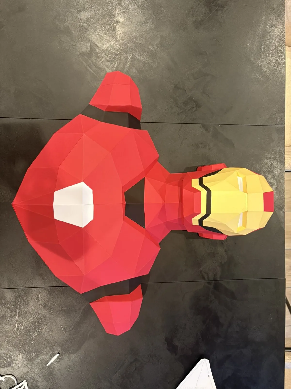 Buste Iron Man rouge doré posé sur table sombre