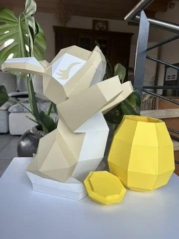 Lapin de Pâques beige tenant œuf jaune ouvert en papier
