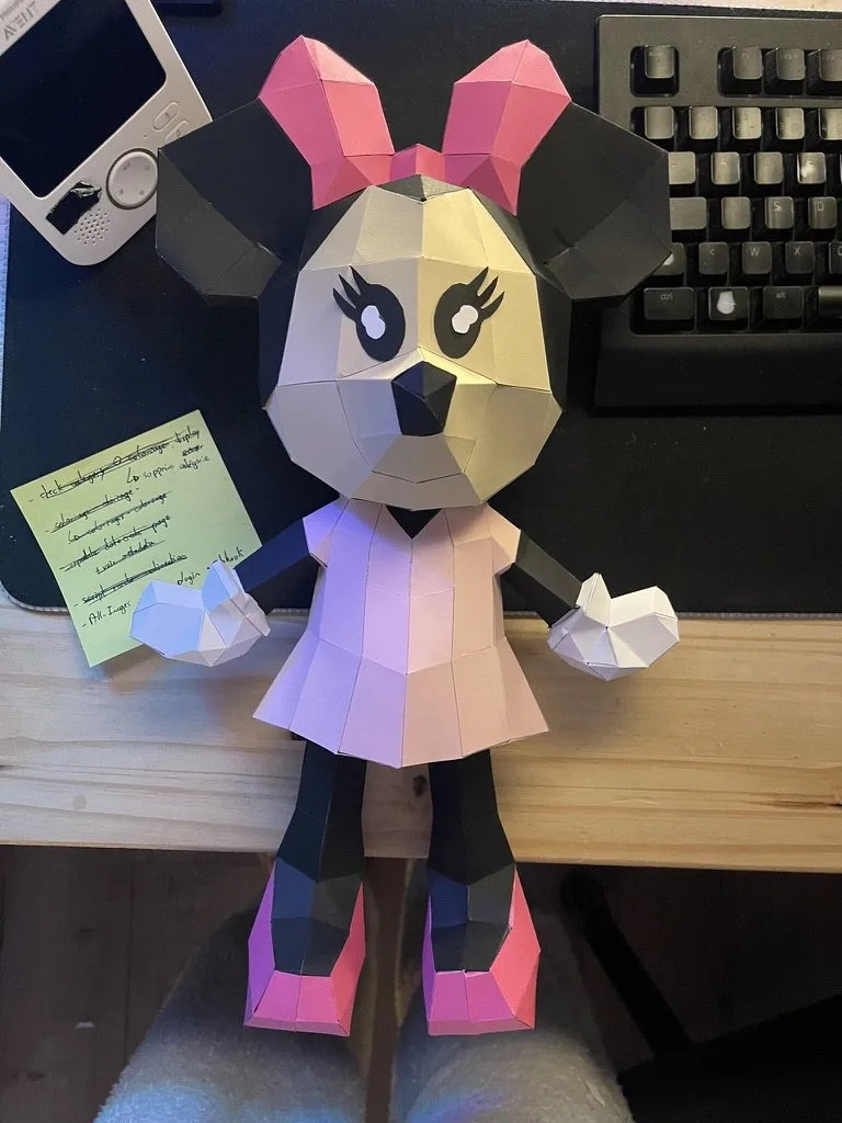 Minnie en papier rose posée sur bureau en bois clair