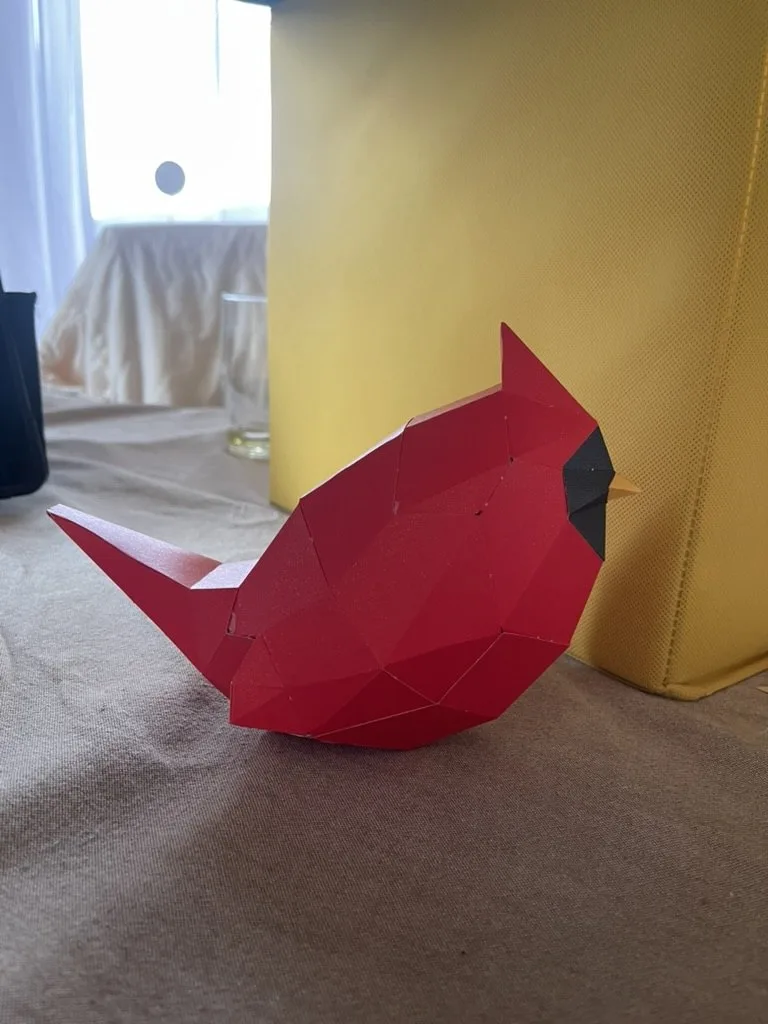 Oiseau rouge masque noir et bec jaune assemblé