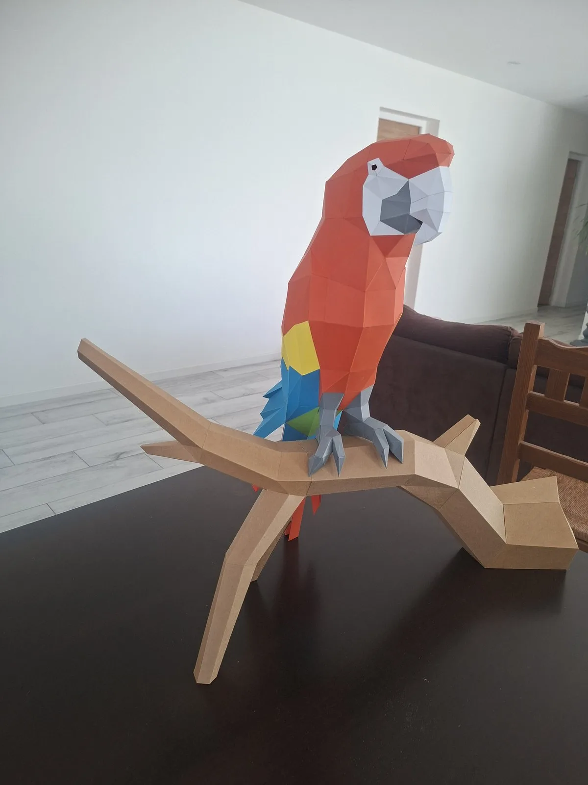 Perroquet Ara en papercraft perché sur une branche en papier